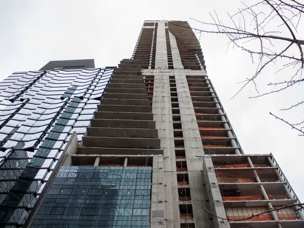 Looking up at the 161 Maiden Lane luxury tower in Manhattan against a blue sky, showing the subtle lean of the structure.